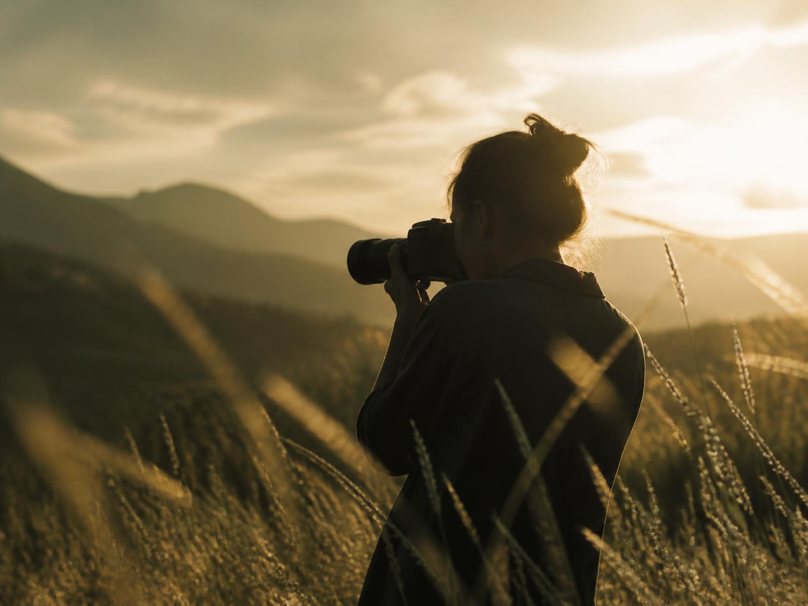Fotógrafa registrando um momento ao entardecer